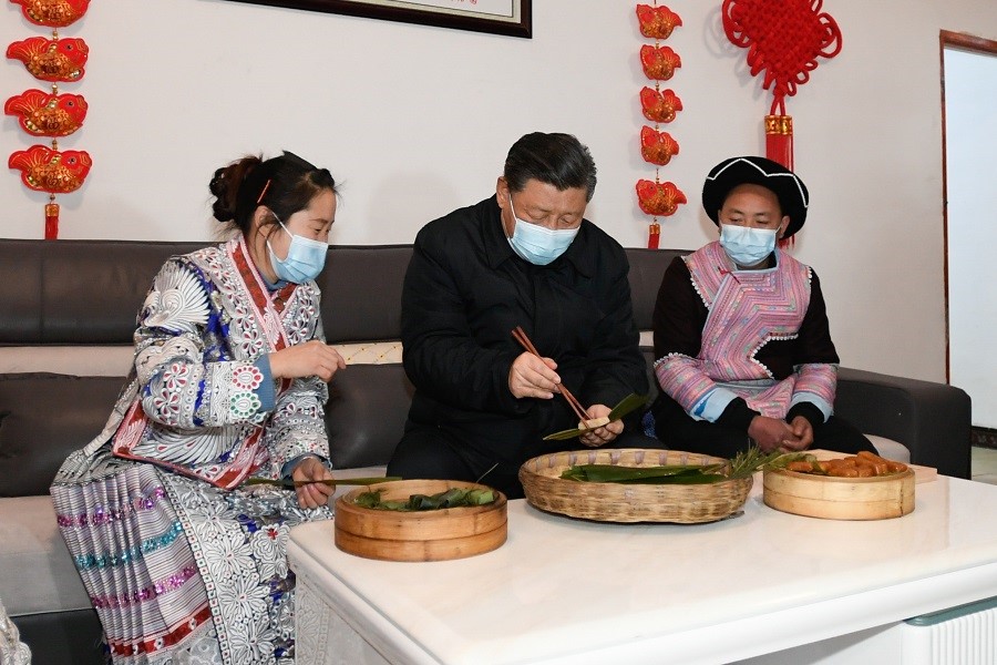 2021年2月3日下午，習(xí)近平在貴州畢節(jié)市黔西縣新仁苗族鄉(xiāng)化屋村苗族村民趙玉學(xué)家，同一家人邊聊家常邊制作當(dāng)?shù)貍鹘y(tǒng)節(jié)日食品黃粑。新華社記者 李學(xué)仁 攝