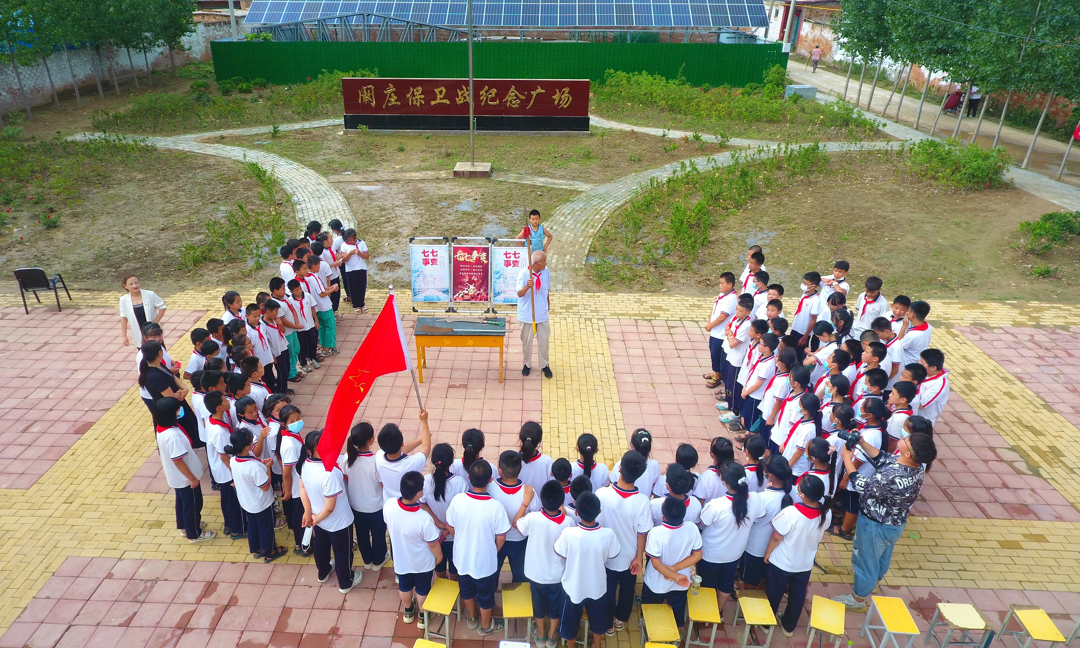 2022年7月6日，山東省聊城市，在茌平區(qū)菜屯鎮(zhèn)闞莊村的闞莊保衛(wèi)戰(zhàn)紀念廣場，闞莊保衛(wèi)戰(zhàn)親歷者王光木老人，為小學生們講述抗戰(zhàn)故事，展示大刀、長矛。